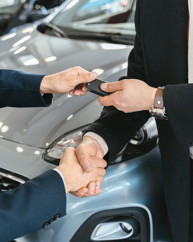 A man receiving keys to a car.