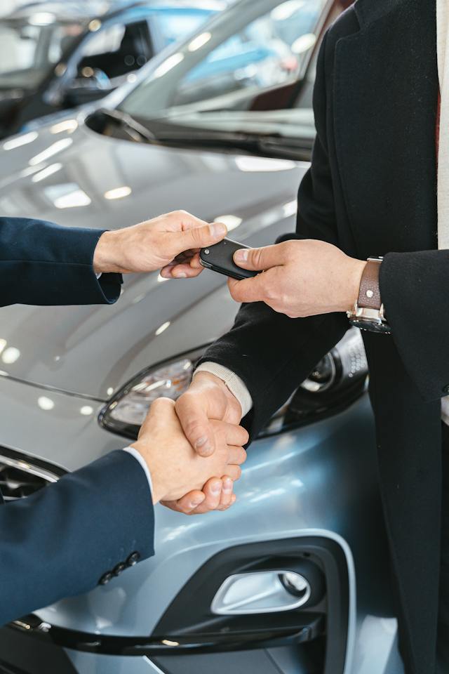 A man receiving keys to a car.