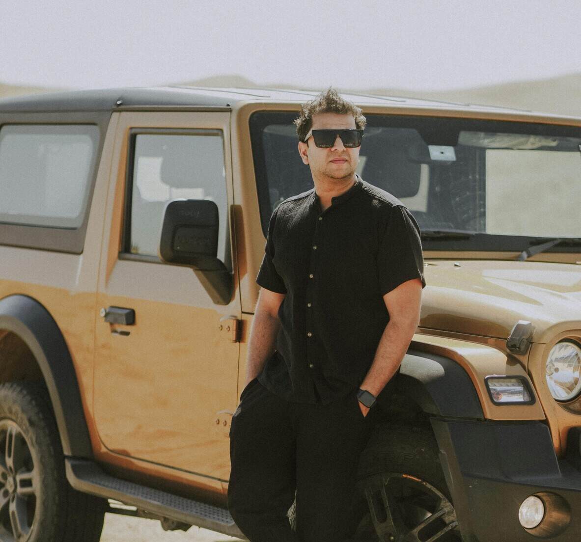 A man leaning on a car.