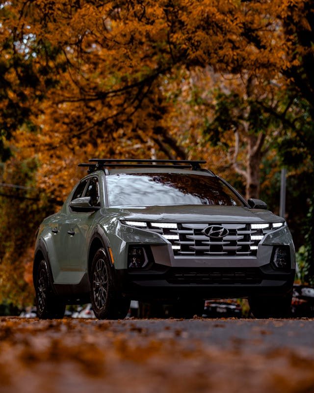 A car underneath various autumn colored trees.