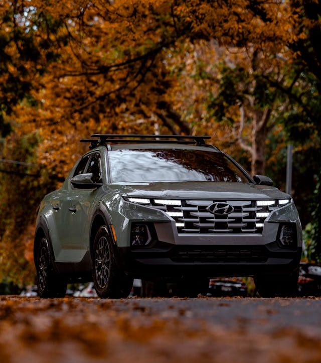 A car underneath various autumn colored trees.