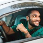 A man sitting in the driver's seat of a car.