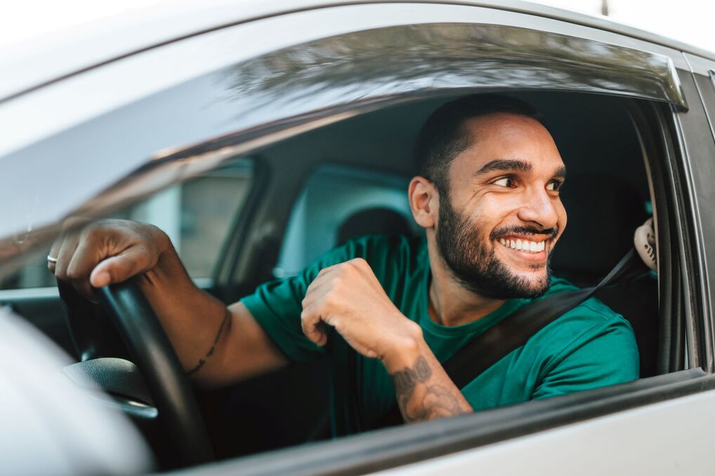 A man sitting in the driver's seat of a car.