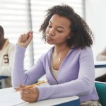 A woman taking an exam on her desk.