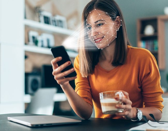 Facial recognition software, on a phone, scanning a woman's face.